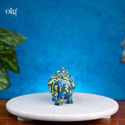 Hand-painted blue wooden elephant figurine with floral and vine art