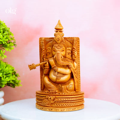 Hand-carved wooden Ganesha idol holding a flute