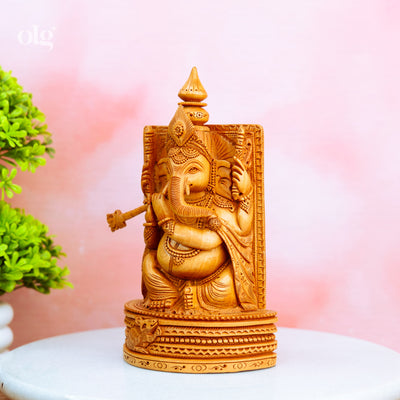 Hand-carved wooden Ganesha idol holding a flute