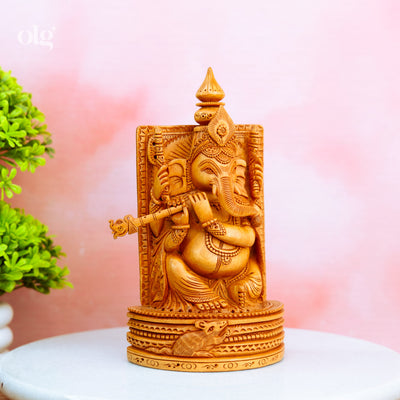 Hand-carved wooden Ganesha idol holding a flute
