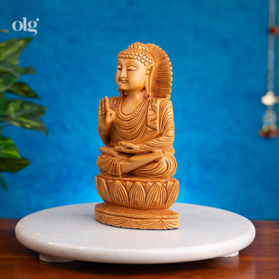 Wooden meditating Buddha figurine in abhaya mudra on lotus base