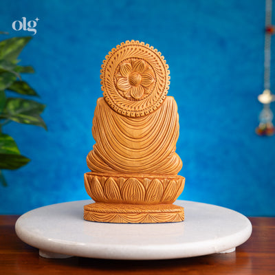 Wooden meditating Buddha figurine in abhaya mudra on lotus base
